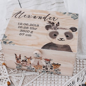 Op de afbeelding: Een houten herinneringsdoos met een pandabeerontwerp en de naam "Alexander" op de deksel. De doos bevat ook de datum "12.06.2018", de tijd "16:28 Uhr", het gewicht "3610 g" en de hoogte "57 cm".