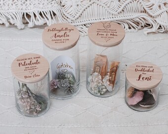 Könnte beinhalten: Vier Glasbehälter mit Holzdeckeln. Jeder Deckel hat eine personalisierte Botschaft. Die Behälter enthalten getrocknete Blumen, einen Geschenkgutschein und andere kleine Gegenstände.