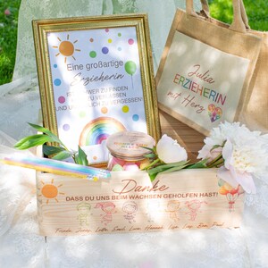 May include: A wooden box, framed print, and tote bag with a gift theme. The box has a sun graphic and text. The framed print has a rainbow and text. The tote bag has text and a heart graphic. Flowers and a jar are also present.