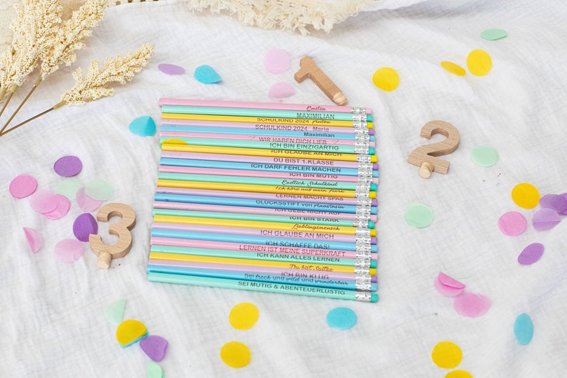 Puede incluir: Un mont&oacute;n de l&aacute;pices de colores con mensajes inspiradores para ni&ntilde;os en edad escolar. Los l&aacute;pices son de color rosa, azul, amarillo y verde. Los mensajes incluyen "Soy &uacute;nico", "Creo en m&iacute;" y "Aprender es mi superpoder".