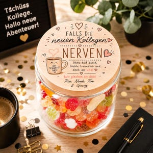 May include: A clear glass jar filled with colorful fruit-shaped gummy candies, topped with a round wooden lid. The lid features engraved German text, a small coffee mug illustration, and the names Pia, Noah, Tim & Georg in black ink.