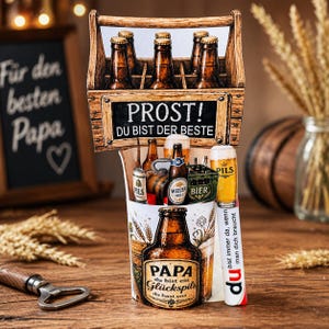 May include: A decorative beer-themed gift set featuring a wooden beer carrier with six bottles, a beer glass, and a bottle opener. The set includes the text "PROST! DU BIST DER BESTE" and "PAPA du bist ein Glückspils".