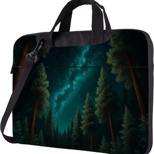 May include: Black laptop bag featuring a forest scene under a starry night sky. The design includes tall trees with green foliage and a dark blue and teal sky. The bag has a black handle and a detachable shoulder strap.