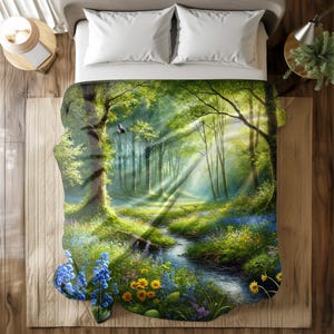 May include: A forest-themed blanket featuring a vibrant landscape with a stream, trees, and flowers. The design showcases a sunny forest scene with light rays, blue and yellow flowers, and a bird in flight. The blanket is placed on a bed.