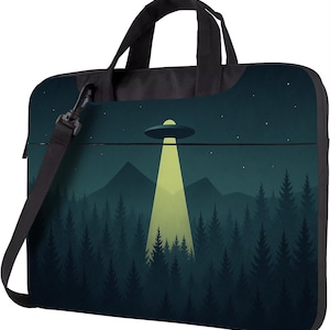 May include: Black laptop bag featuring a UFO design shining a light over a forest. The image shows a dark green forest, mountains, and a starry night sky. Includes a black shoulder strap and handle.