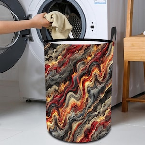 May include: A laundry hamper with a black fabric top and a colorful abstract design. The design features swirling lines of red, orange, yellow, and gray.