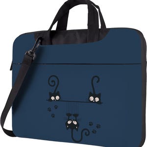 Op de afbeelding: Marineblauwe laptoptas met een zwarte handgreep en schouderriem. De tas heeft een speels ontwerp van drie zwarte cartoonkatten, met verspreide pootafdrukken.
