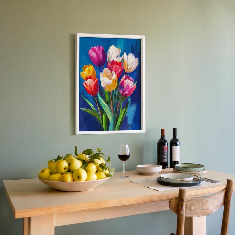 May include: A framed painting of colorful tulips in shades of red, pink, yellow, and white against a blue background. The painting hangs above a wooden table set with a bowl of yellow fruit, wine glasses, and bottles of wine.