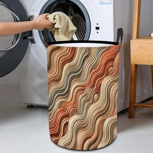 May include: A brown and beige laundry hamper with a wavy pattern. The hamper is made of fabric and has a black drawstring.