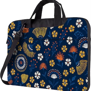 Op de afbeelding: Een marineblauwe laptoptas met een bloemenpatroon met gele, witte en oranje bloemen. De tas heeft een zwart handvat en een afneembare schouderriem. Het bloemenpatroon herhaalt zich.