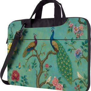 Puede incluir: Bolso para portátil de color turquesa con diseño de pavo real. El bolso tiene un asa y una correa para el hombro negras. La ilustración del pavo real incluye un pavo real macho con una larga cola verde y azul, y una pava. El diseño también incluye flores y pájaros.