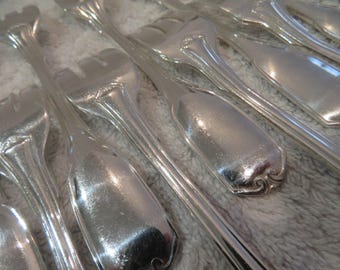May include: A set of silver forks with ornate handles. The forks are arranged in a row, with the handles pointing towards the viewer. The forks are polished and shiny.