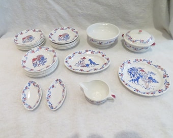 May include: A vintage children's tea set with a red, white, and blue floral pattern. The set includes a teapot, creamer, sugar bowl, plates, and bowls. The set is made of ceramic and is in good condition.