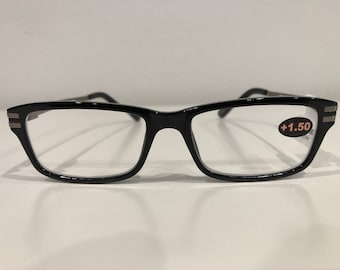 Puede incluir: Gafas de lectura rectangulares negras con una graduación de +1,50. Las gafas tienen un borde plateado alrededor de las lentes.