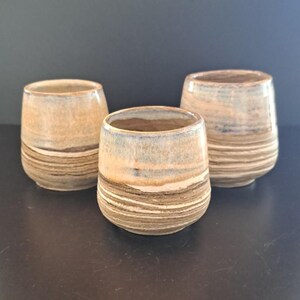 Keramikbecher, aus verschiedenen Tonsorten. Auf der Töpferscheibe entstehen beim Drehen einzigartige Muster. So ist jeder Becher ein Unikat.