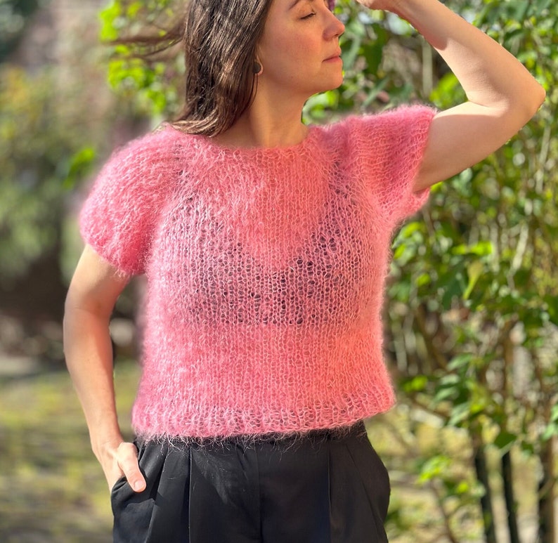 zarter Strick mit langen Fasern, der Schnitt ist bei Größe M/L eher schmal, die Kurzen Ärmel haben T-Shirt Länge. Die Farbe ist ein kräftigeres Rosa