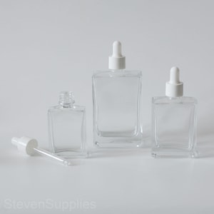 Flaconi contagocce trasparenti da 1 oz 30 ml 50 ml 100 ml Vetro quadrato con tappo bianco per cosmetici Cura della pelle Trucco Contagocce viso / occhi Logo personalizzato sulla bottiglia