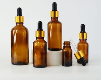 May include: Amber glass dropper bottles with black droppers and gold collars. The bottles are in various sizes, arranged on a white surface. The image includes the text "ETSY STORE STEVENSSUPPLIES" at the top.