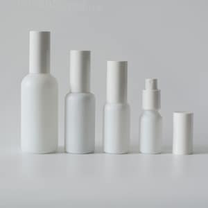 Op de afbeelding: Een verzameling van vijf witte, cilindervormige flessen met bijpassende witte doppen. De flessen variëren in grootte, één met een sproeikop. Ze zijn in een rij gerangschikt tegen een effen witte achtergrond. De tekst "StevenSupplies" is linksboven zichtbaar.