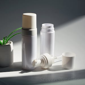 May include: Two white plastic foam pump bottles with a white plastic pump head and a white plastic cap. The bottles are on a white surface.