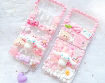 Pode incluir: Quatro capas de telefone rosa e brancas decoradas com enfeites 3D, incluindo um personagem de cachorro de desenho animado, flores e doces. As capas têm um design de espiral rosa e branco ao redor das bordas.