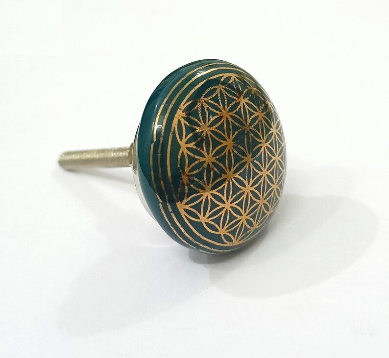 Peut inclure: Un bouton de porte en c&eacute;ramique verte avec un motif dor&eacute; de la fleur de vie.