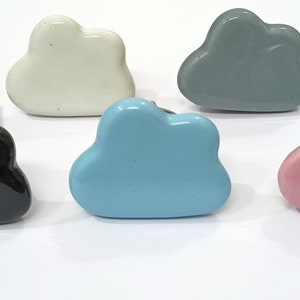 Puede incluir: Seis pomos de armario de cer&aacute;mica en forma de nube en varios colores: blanco, gris, negro, azul claro y rosa. Cada pomo tiene un tornillo plateado.