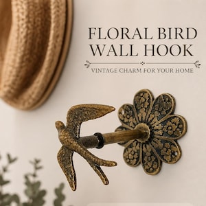 Puede incluir: Un colgador de pared de color bronce con un diseño de pájaro y flor. El colgador presenta una silueta de pájaro y una base en forma de flor, con el texto "FLORAL BIRD WALL HOOK" y "VINTAGE CHARM FOR YOUR HOME".
