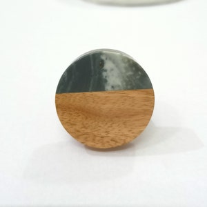 Puede incluir: Un pomo redondo de madera con una parte superior de m&aacute;rmol verde y blanco. El pomo es perfecto para agregar un toque de elegancia r&uacute;stica a cualquier armario o caj&oacute;n.