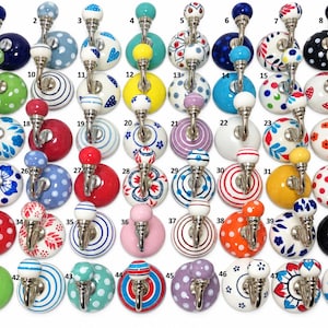 May include: A collection of forty-eight ceramic wall hooks, each featuring a round knob with various colorful patterns, including polka dots, stripes, and floral designs, attached to a silver-toned metal hook base, numbered one through forty-eight.