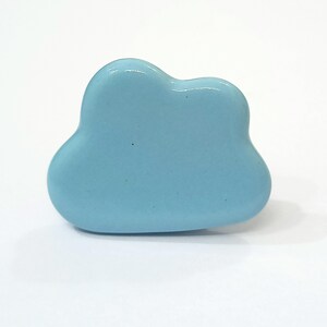 Puede incluir: Un pomo de cer&aacute;mica en forma de nube de color azul claro.