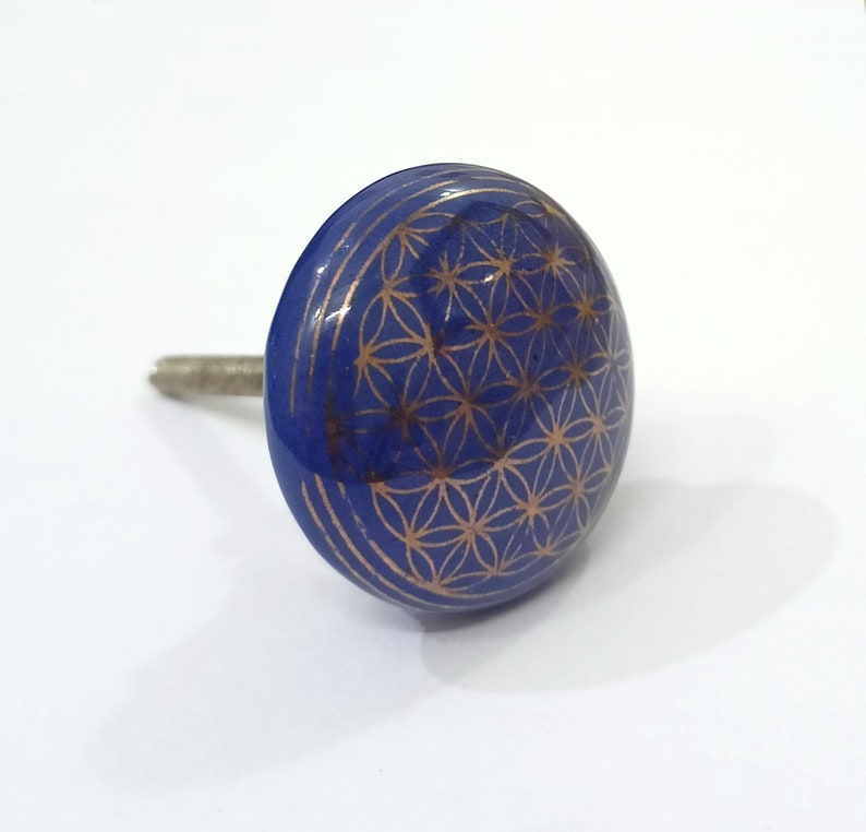 Peut inclure: Un bouton de cabinet en c&eacute;ramique bleu avec un motif dor&eacute; de la fleur de vie.