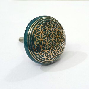 Peut inclure: Un bouton de cabinet en c&eacute;ramique bleu sarcelle avec un motif dor&eacute; de fleur de vie.