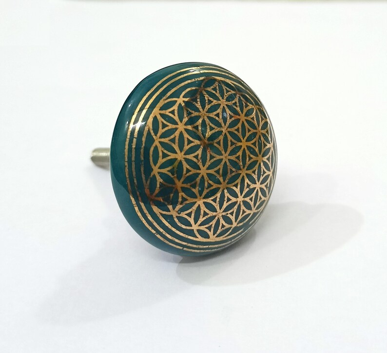 Peut inclure: Un bouton de cabinet en c&eacute;ramique bleu sarcelle avec un motif dor&eacute; de fleur de vie.