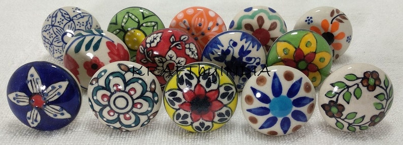 Pode incluir: Conjunto de 12 bot&otilde;es de gaveta de cer&acirc;mica com padr&otilde;es florais coloridos. Os bot&otilde;es s&atilde;o redondos e t&ecirc;m uma base branca com v&aacute;rias cores, incluindo azul, verde, vermelho, amarelo e laranja.