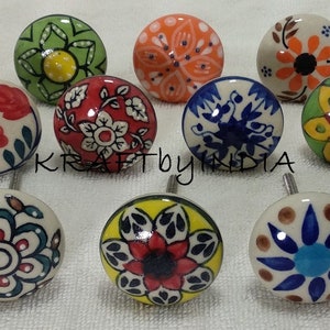 Pode incluir: Conjunto de 12 bot&otilde;es de cer&acirc;mica com v&aacute;rios desenhos florais e geom&eacute;tricos em azul, verde, vermelho, amarelo e laranja. Os bot&otilde;es t&ecirc;m aproximadamente 2,5 cm de di&acirc;metro e um fundo branco.