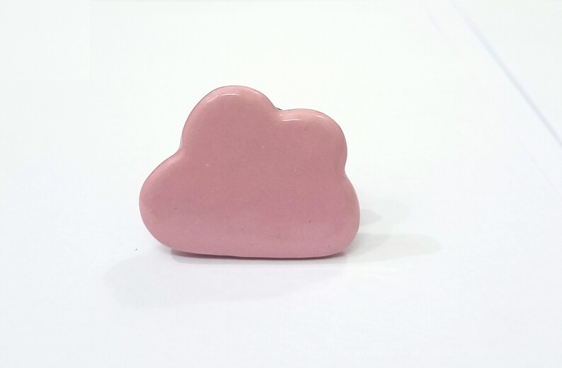 Puede incluir: Un pomo de cer&aacute;mica de color rosa en forma de nube para un caj&oacute;n o un armario.