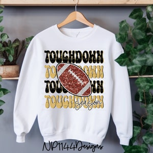 May include: White sweatshirt with a gold and black graphic that says "Touchdown Season" with a football in the center.