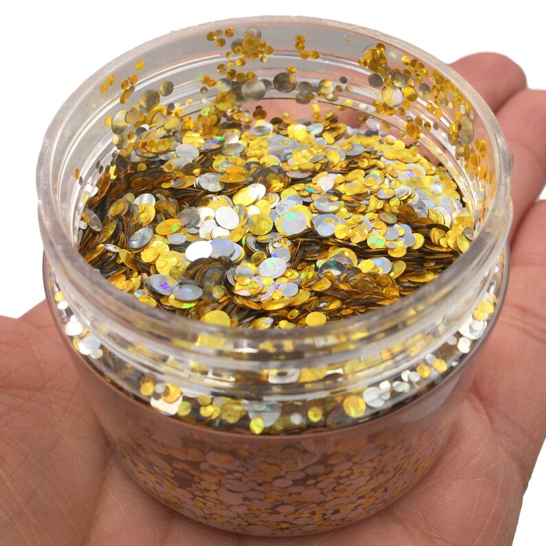 May include: A clear plastic jar filled with gold and silver glitter. The glitter is in the shape of small circles.