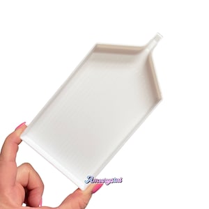 May include: White plastic diamond painting tray with a raised lip and a spout on one end. The tray has a textured surface.