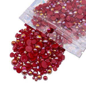 May include: A bag of red iridescent pearl beads and flat back cabochons. The beads are a mix of sizes and are perfect for crafting.