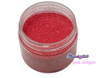 May include: A clear plastic jar filled with red glitter. The jar has a white label with the text "Amecrystal pink dragon".