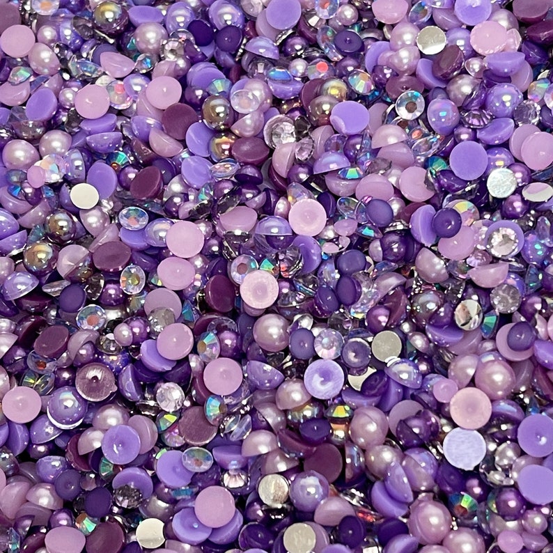 May include: A mix of purple, lavender, and iridescent round and flat embellishments. These decorative beads are perfect for crafting and adding sparkle to projects.
