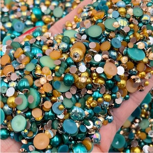 May include: A mix of green, gold, and brown iridescent glass beads and rhinestones. The beads are various sizes and shapes, including round, oval, and flat.