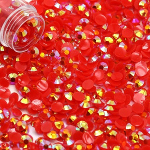 May include: A large quantity of red iridescent rhinestones, some with a flat back and some with a pointed back.