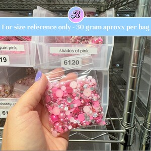 Pode incluir: Um saco de pl&aacute;stico transparente cheio de contas e strass rosa e prateados. O saco est&aacute; etiquetado com "shades of pink" e "6120". O texto "For size reference only - 30 gram approx per bag" est&aacute; na parte superior da imagem.