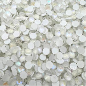 May include: A large quantity of white iridescent round rhinestones with adhesive backing.