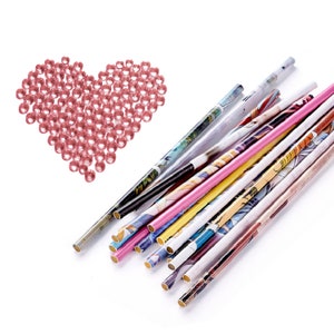 May include: A heart shape made of pink rhinestones with a pile of colorful paper straws with printed designs.