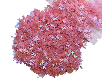 May include: Pink iridescent glitter in the shape of ribbon bows.