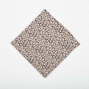 May include: A brown fabric handkerchief with a white and light blue floral pattern.